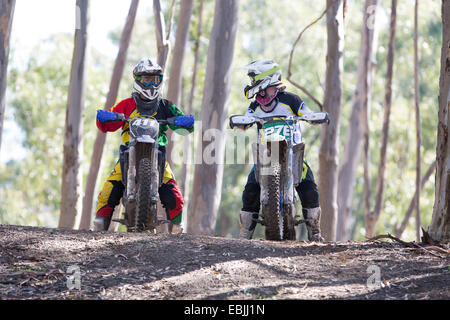 Due maschi giovani piloti di Motocross chiacchierando in foresta Foto Stock