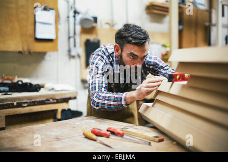 Coppia artigiano utilizzando la livella in organo a canne workshop Foto Stock