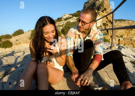Coppia giovane seduto in chat a costa, Marsiglia, Francia Foto Stock