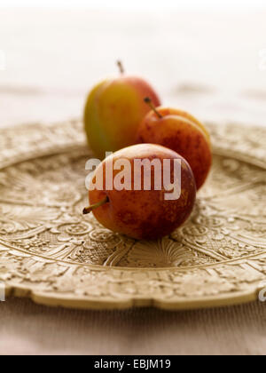 Victoria prugne sulla piastra decorativa, close-up Foto Stock