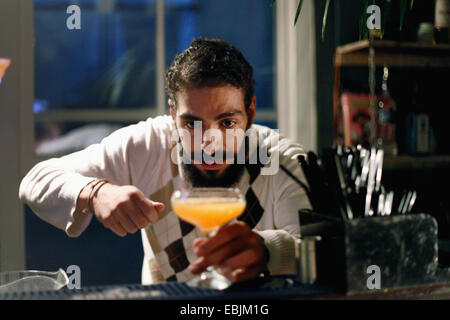 Il Barista serve cocktail al bar Foto Stock