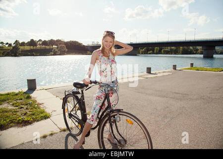 Ritratto di giovane donna con la bicicletta su Riverside, Isola del Danubio, Vienna, Austria Foto Stock