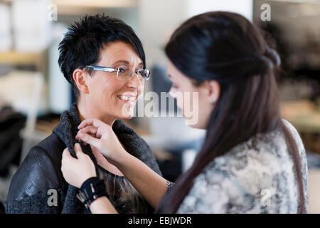 Giovane sarta rimpalli di spallamento della camicia di clienti in officina Foto Stock