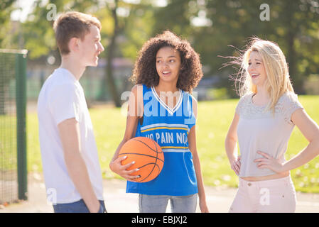 Tre adulti giovani giocatori di basket in chat Foto Stock