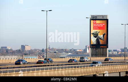 Macchine passano un illuminato pubblicità stradale board accanto all'autostrada M5, Oldbury, Birmingham. Tra i raccordi 3 e 2. Foto Stock