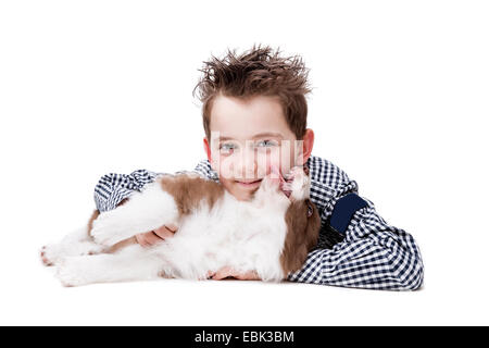 Little Boy e un Border Collie cucciolo di fronte a uno sfondo bianco Foto Stock