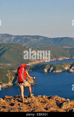 Femmina wanderer godendo la vista della costa Corsians, Francia, Corsica, Capo Rosso Foto Stock