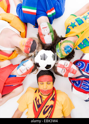 Sleeping internazionale di giovani persone con facce dipinte in colori nazionali Foto Stock