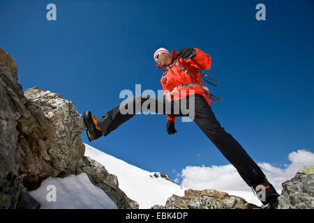 Scalatore a cavallo su un abisso di roccia, Austria, Grossglocknergebiet Foto Stock