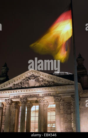 Il palazzo del Reichstag a Berlino con bandiera tedesca di notte, Germania Foto Stock