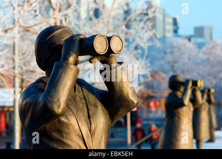 Alcune sculture in bronzo di persone in piedi a fianco a fianco osservando la distanza attraverso il binocolo di Brema artista Thomas Recker in testa al porto di Bremen-Vegesack, Germania, Brema Foto Stock