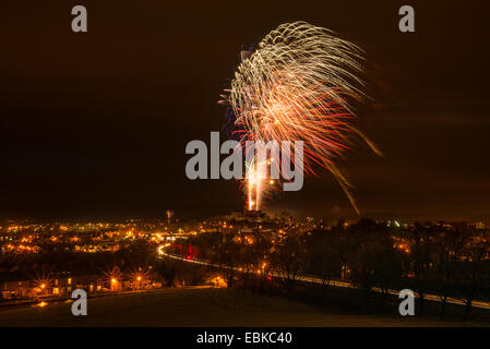 Fuochi d'artificio su Lancaster Castle Lancashire Inghilterra. In primo piano le luci di una Vergine soutbound treno pendolino Foto Stock