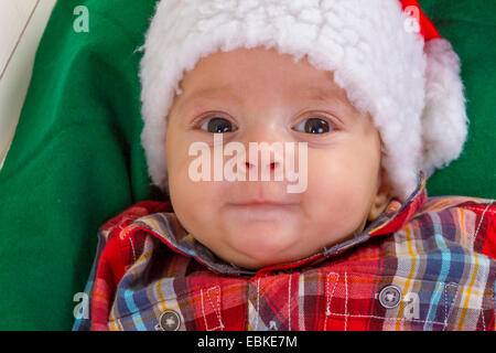 Carino baby boy sorridente in un santa claus hat close-up Foto Stock