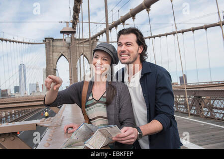 Stati Uniti d'America, nello Stato di New York, New York, Brooklyn, coppia felice con la mappa sul ponte di Brooklyn Foto Stock