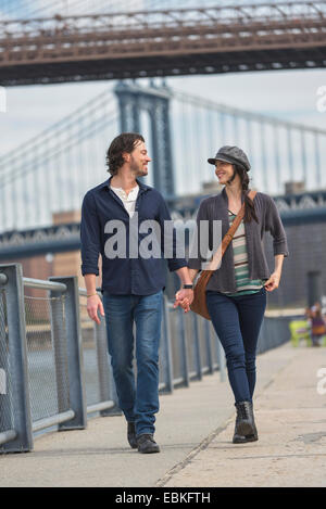 Stati Uniti d'America, nello Stato di New York, New York, Brooklyn, giovane passeggiate sul lungomare, il Ponte di Brooklyn in background Foto Stock