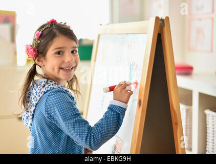 Ritratto di ragazza (6-7) scrivendo a bordo in aula Foto Stock