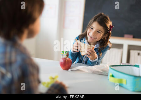 Gli alunni (6-7) di mangiare il pranzo in aula Foto Stock