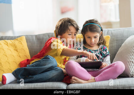 Bambini (6-7) giocando su tablet pc a casa Foto Stock