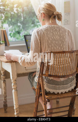 Vista posteriore della donna che lavorano con il computer portatile Foto Stock