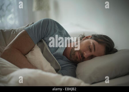 Uomo dorme nel letto Foto Stock