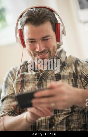 Uomo sorridente ascolto di musica Foto Stock