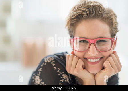 Ritratto di giovane sorridente donna che indossa gli occhiali Foto Stock