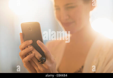 Giovane donna utilizzando il telefono cellulare Foto Stock
