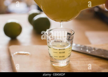 Close-up di liquido che viene versato nel colpo di vetro Foto Stock