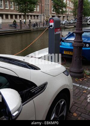 Ricarica di veicoli elettrici presso una stazione sul canale di Amsterdam, Paesi Bassi, Europa Foto Stock