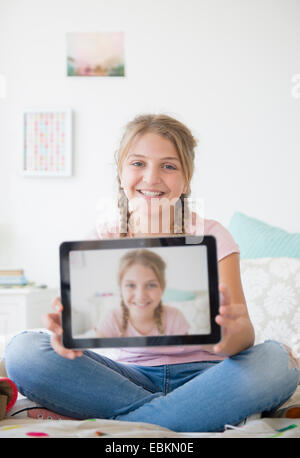 La ragazza (12-13) azienda tablet con selfie Foto Stock
