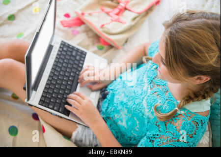 La ragazza (12-13) utilizzando il computer portatile in camera da letto Foto Stock