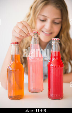 La ragazza (12-13) e tre bottiglie di soda Foto Stock