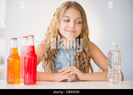 La ragazza (12-13) scegliendo tra acqua e bicarbonato di sodio Foto Stock