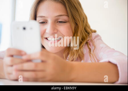 La ragazza (12-13) utilizza lo smartphone Foto Stock