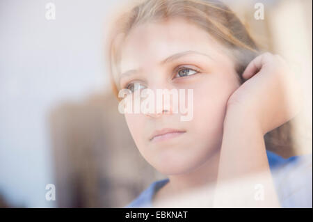 Ritratto di ragazza adolescente (12-13) guardando attraverso la finestra Foto Stock