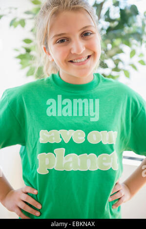 Ritratto di sorridente ragazza adolescente (12-13) verde che indossa la t-shirt Foto Stock