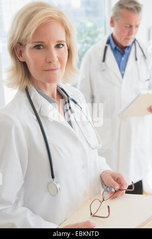 Ritratto di medico donna holding negli appunti e occhiali Foto Stock