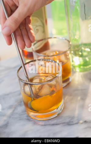 Studio shot di donna di mano drink di agitazione Foto Stock