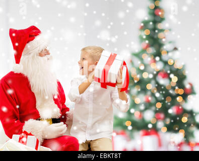 Sorridente ragazzino con Babbo Natale e regali Foto Stock