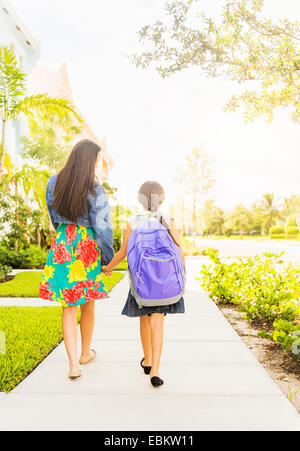 Stati Uniti d'America, Florida, Giove, vista posteriore di una ragazza (6-7) tenendo le mani con la sua mamma all'aperto Foto Stock