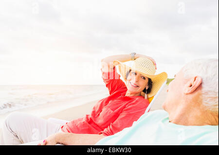 Stati Uniti d'America, Florida, Giove, vista del giovane seduto in sedie a sdraio sulla spiaggia Foto Stock