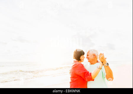 Stati Uniti d'America, Florida, Giove, coppia danzante sulla spiaggia al tramonto Foto Stock