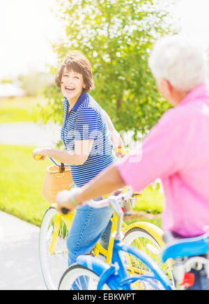 Stati Uniti d'America, Florida, Giove, ritratto di donna guardando sopra la spalla a uomo senior, mentre ottenere sulla bicicletta e ridere Foto Stock