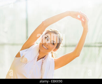 Ritratto di giovane donna stretching Foto Stock