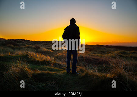 Southport, Merseyside, Regno Unito. 2 dicembre, 2014. Silhouette uomo. Regno Unito Meteo come si vede a Ainsdale dune di sabbia riserva naturale nazionale (NNR). Una chiara notte fredda in prospettiva con temperature sotto zero previsioni per il west regione costiera del Nord Inghilterra come il sole tramonta sul mare d'Irlanda. Foto Stock