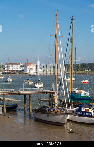 Barche ormeggiate lungo il fiume Deben a Woodbridge con mulino di marea in distanza Foto Stock