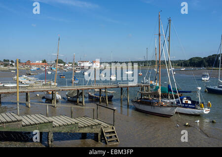 Barche ormeggiate lungo il fiume Deben a Woodbridge con mulino di marea in distanza Foto Stock