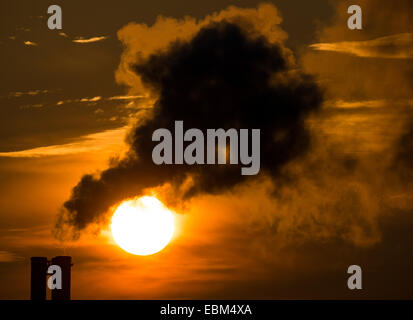 Il sole del mattino splende dietro al fumo del camino di un blocco della stazione di riscaldamento a Francoforte/Oder, Germania, 27 novembre 2014. Foto: Patrick Pleul Foto Stock