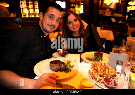 Coppia giovane godetevi una notte fuori a Bobby Van's Steakhouse West 50th Street New York con piatto di firma di filetto mignon bistecca Foto Stock