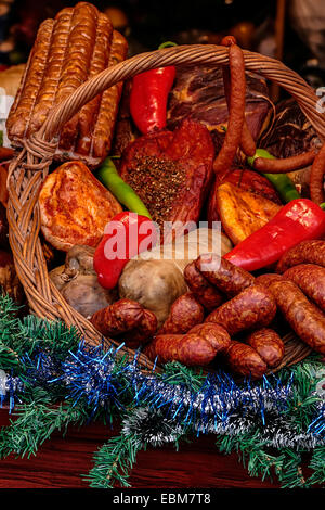 Varie salsicce affumicate specialità, collocati in un cesto di vimini. Esposto in vendita. Specifico per dicembre. Foto Stock